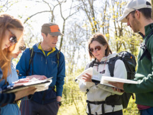 Participants learning map reading and compass navigation skills on a beginner outdoor navigation course.